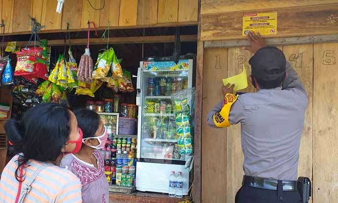 Imbau Warga Cegah Corona, Bhabinkamtibmas Bagikan Stiker Kepada Warga