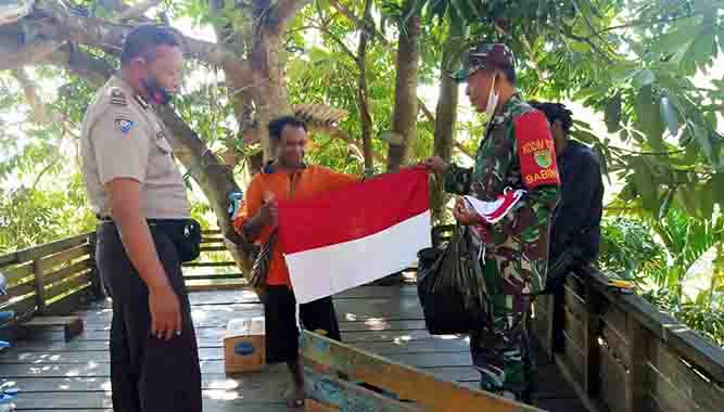 Jelang HUT RI Ke-75, Bhabinkamtibmas dan Babinsa Bagikan Bendera Ke Warga