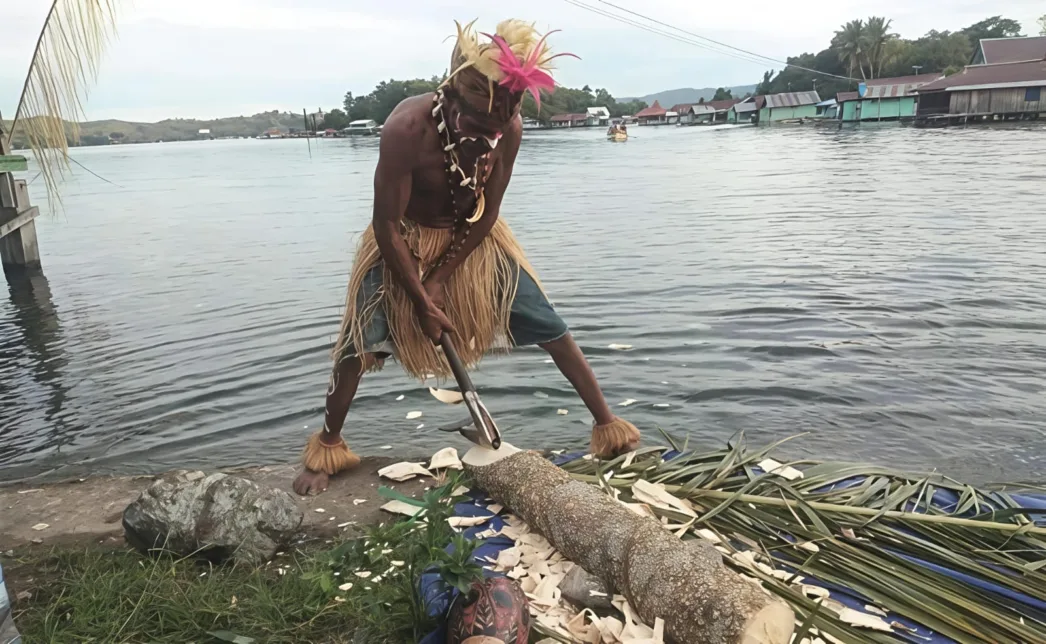Pengrajin Isak Yoku Pamerkan Cara Pembuatan Perahu Tradisional Howakhu di Hadapan Wisatawan Asing di Kampung Yobeh